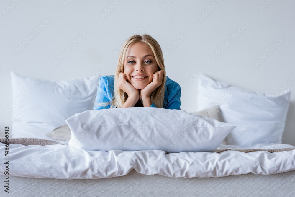 smiling young woman lying on pillow in bedroom smiling young woman lying on pillow in bedroom