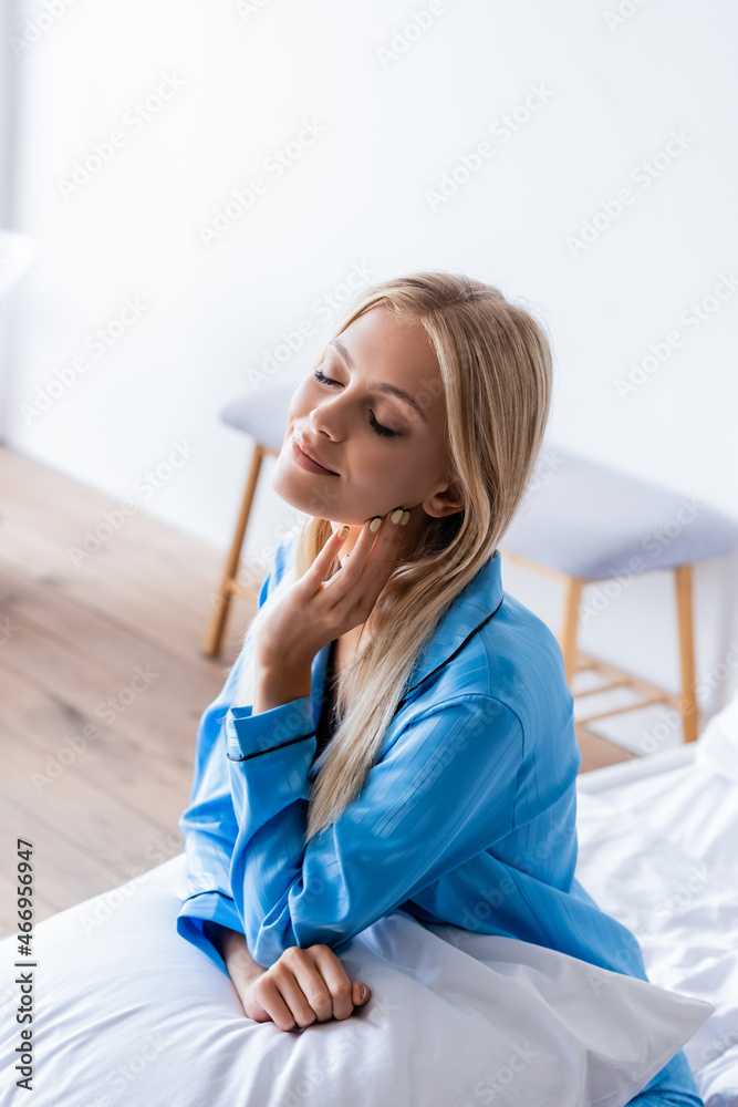 high angle view of joyful young woman sitting on bed high angle view of joyful young woman sitting on bed