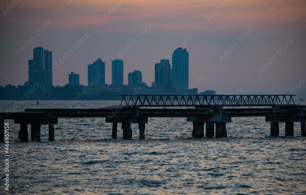 Abandoned bridge in the middle of the sea during sunset at Chittaphawan Temple, Chonburi Province, Thailand