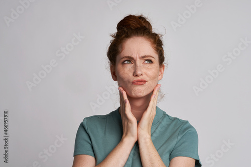 Beautiful uncertain redhead woman at the studio photo