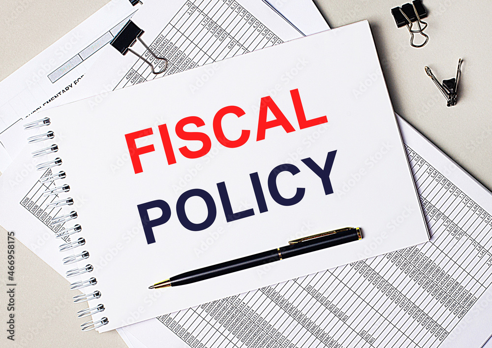 On the desktop there are documents, pen, black paper clips and a notebook with the text FISCAL POLICY. Business concept On the desktop there are documents, pen, black paper clips and a notebook with the text FISCAL POLICY. Business concept