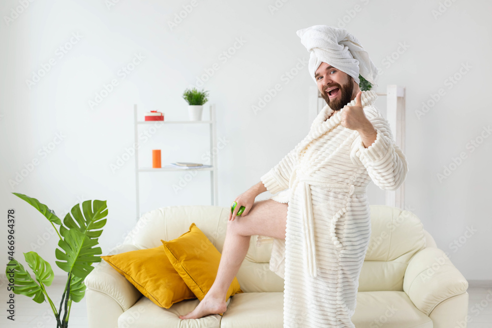 Funny bearded man wear turban towel makes himself a massage with massage brush. Male skin care and spa concept. Funny bearded man wear turban towel makes himself a massage with massage brush. Male skin care and spa concept.