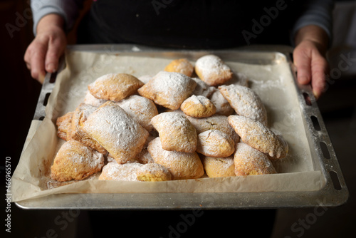 Closeup of woman holding a baking tray full of cookies 