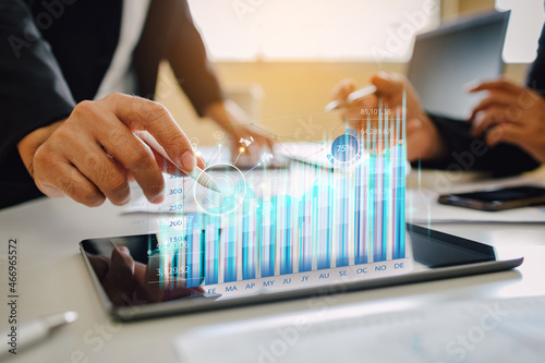 Business analyzing big data screen and economic growth with financial diagram graph interfaces. Concept of virtual dashboard technology digital marketing and global network connection from tablet.