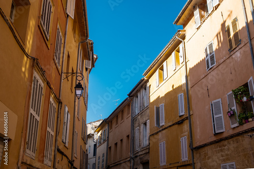 Colorful and beautiful small alley in the old town of the french city of Aix en Provence on a summer day with clear blue sky and traditional houses and architecture