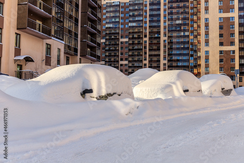 Cars covered in snow after heavy snowfall. Frosty sunny day. St. Petersburg. Russia