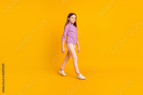 Full size profile side photo of happy positive good mood pretty girl go walk travel isolated on yellow color background