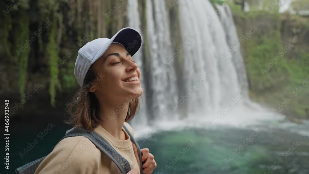 portrait of happy beautiful young woman tourist on huge Upper Duden Waterfall background in Antalya. Famous view point and touristic place in Turkey.