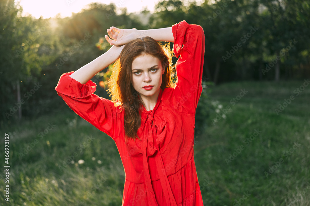 attractive woman in red dress posing in nature green grass attractive woman in red dress posing in nature green grass