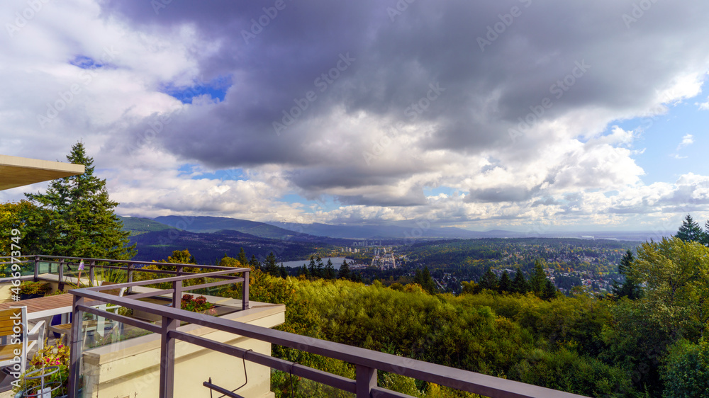 Rain clouds approaching over Fraser Valley, BC, as viewed from a rooftop patio at Univercity Highlands on Burnaby Mountain, BC.