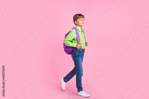 Full length body size view of attractive trendy boy going to secondary school isolated over pink pastel color background