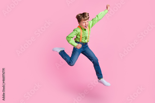 Full length body size view of attractive cheerful trendy lucky boy jumping rejoicing isolated over pink pastel color background