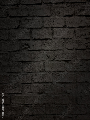 close up shot at the surface of black bumpy brick pattern wall with stamped of dog footprint. natural stone brick wall texture for loft  industrial concept design. high defination image.