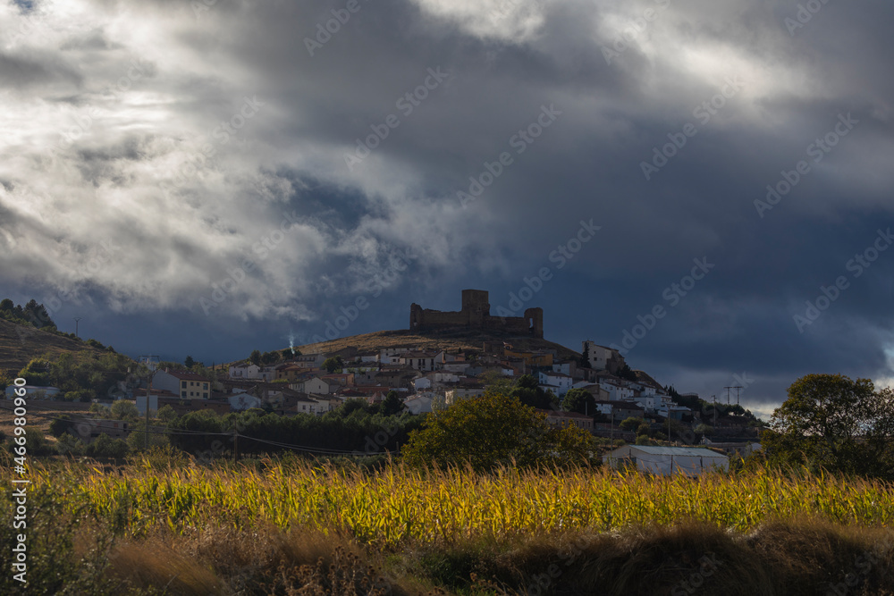 View of the small town of Trasmoz and its unmistakable castle from the 12th century, against a dark, sunset and cloud-covered landscape, Aragon