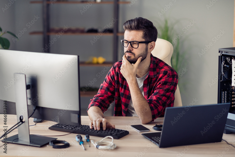 Portrait of attractive qualified minded guy senior web dev programming brainstorming at office work place station indoor Portrait of attractive qualified minded guy senior web dev programming brainstorming at office work place station indoor