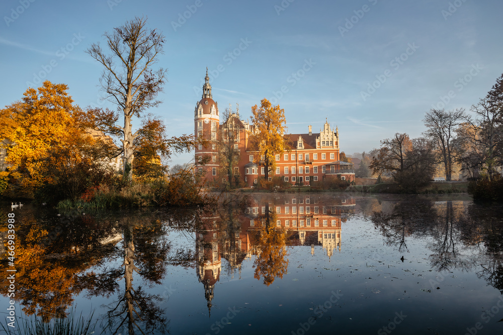 Prince Pueckler Park and castle reflected in water,Bad Muskau on German Polish border.Spectacular panoramic view of scenic fall landscape.UNESCO Site.Masterpiece on Neisse River.Tourist cultural place