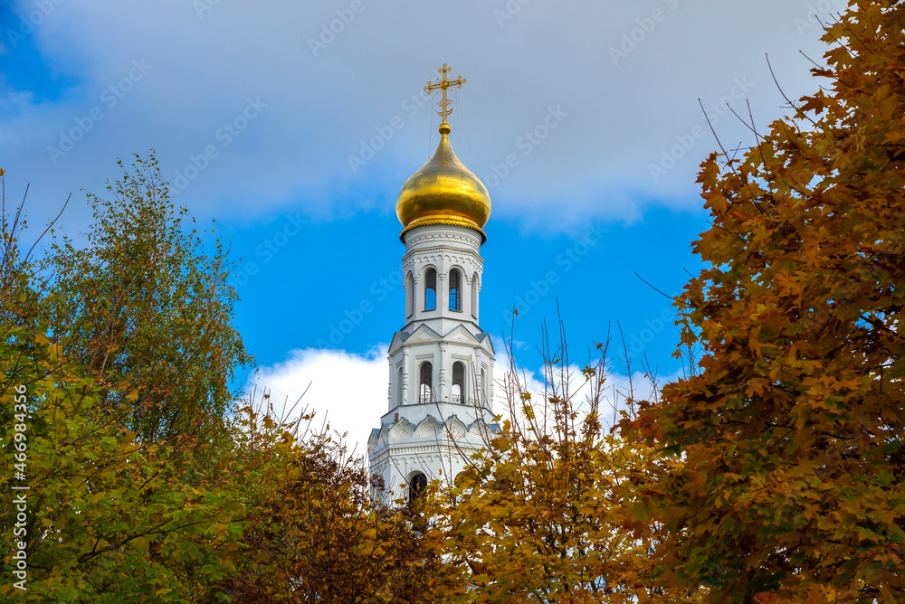 View on the bell tower of the Trinity Church on the background of the autumn sky. The temple complex in Zavidovo. Tver region, Russia