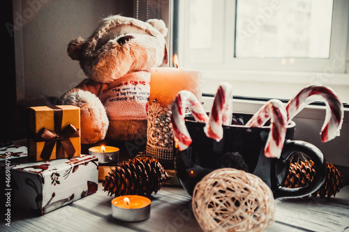 Soft toy and candles on wooden white background with christmas decorations photo