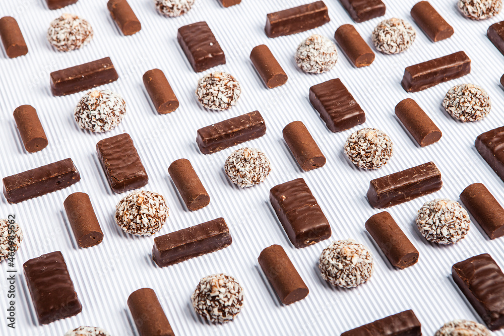 Assorted chocolate candies on wooden background. Chocolate sweets. Dessert background. Assorted chocolate candies on wooden background. Chocolate sweets. Dessert background.