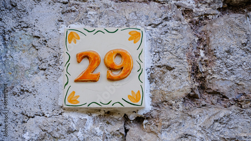 Ceramic house number on wall. number twenty-nine. 29 photo