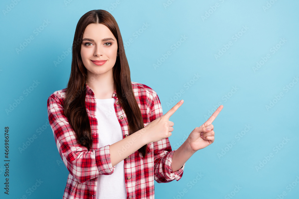 Photo of young girl happy positive smile point fingers empty space advertise recommend isolated over blue color background Photo of young girl happy positive smile point fingers empty space advertise recommend isolated over blue color background