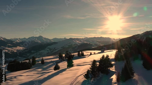 Golden Sun Light at Sunset in Mountains. Beautiful Sunny evening. Aerial view of Winter Mountains. Beautiful Winter Landscape. Flying above Snowy Alps mountains. photo