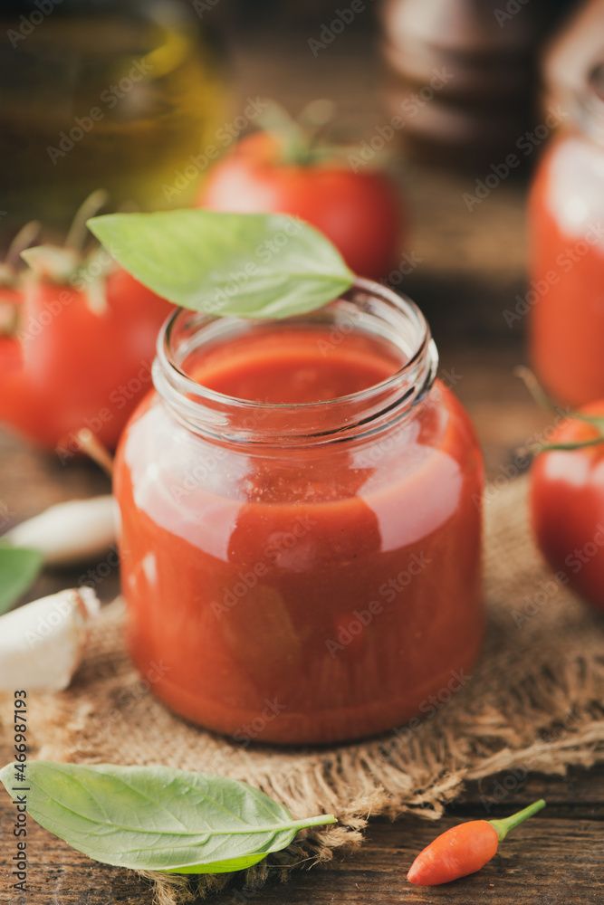 Jar of home made classic Tomato sauce on wooden table Jar of home made classic Tomato sauce on wooden table
