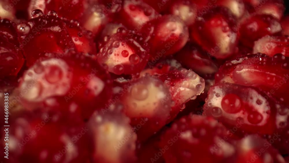 Macro shot of juicy red berries of the fruits of the pomegranate tree are covered with large drops of water. Fresh fruit ready to eat. High quality. 4k footage. Macro shot of juicy red berries of the fruits of the pomegranate tree are covered with large drops of water. Fresh fruit ready to eat. High quality. 4k footage.