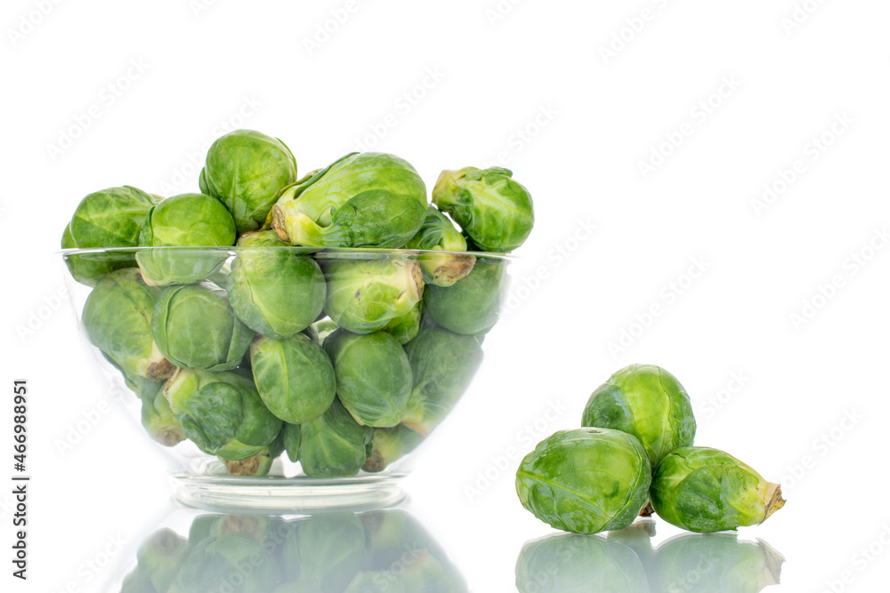 Obraz premium Organic ripe brussels sprouts in a glass bowl, close-up, isolated on white.