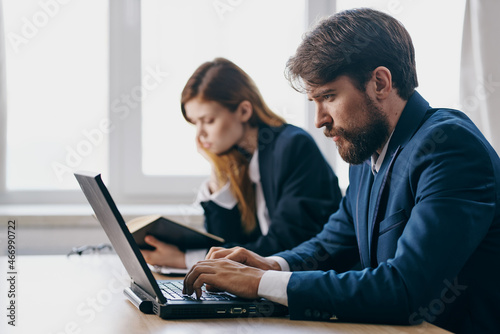 business man and woman sitting at a desk with a laptop communication finance professionals