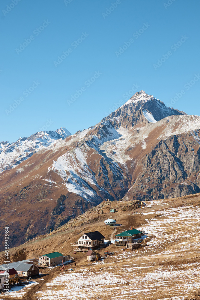 A house in the mountains, a village on a slope, snow cliffs, life in the mountains, a house on top of a mountain