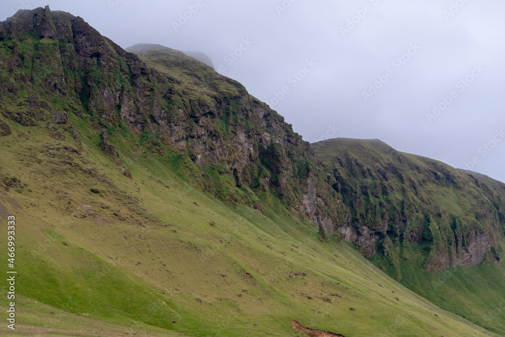 Cloudy landscape of grassy mountain cliff near Vik South Iceland