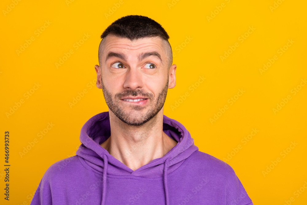 Photo of cute millennial brunet guy look empty space wear violet hoodie isolated on yellow color background Photo of cute millennial brunet guy look empty space wear violet hoodie isolated on yellow color background