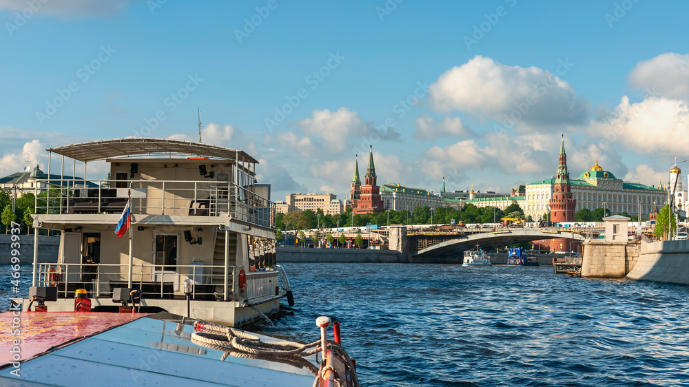 Obraz premium view from a tourist ship on the Moskva River and the towers of the Moscow Kremlin against the background of a blue cloudy sky