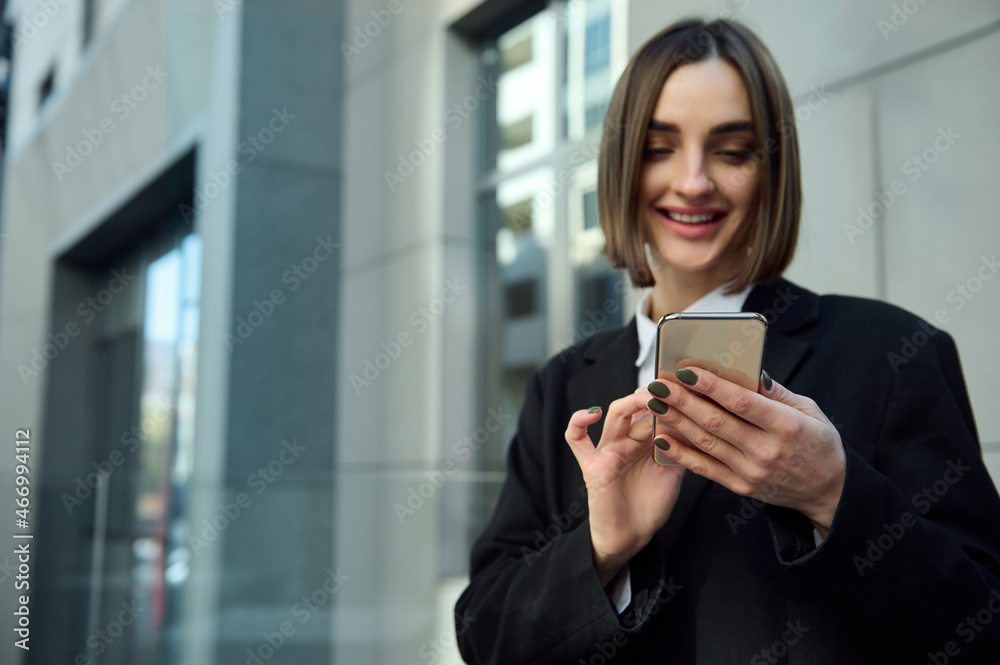 Smiling cheerful woman holding mobile phone smartphone, typing text messages, messaging, swiping web page. Business, finance, online remote work, online shopping, communication and connection concepts Smiling cheerful woman holding mobile phone smartphone, typing text messages, messaging, swiping web page. Business, finance, online remote work, online shopping, communication and connection concepts