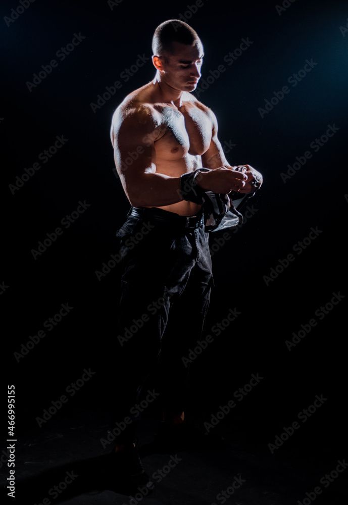 Young handsome sport model man with a healthy body takes off his shirt Young handsome sport model man with a healthy body takes off his shirt