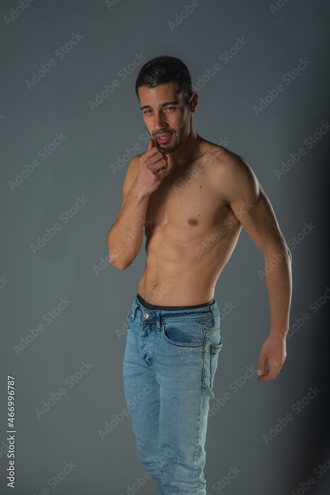 Studio portrait of a shirtless sexy man with abs in denim blue jeans Studio portrait of a shirtless sexy man with abs in denim blue jeans