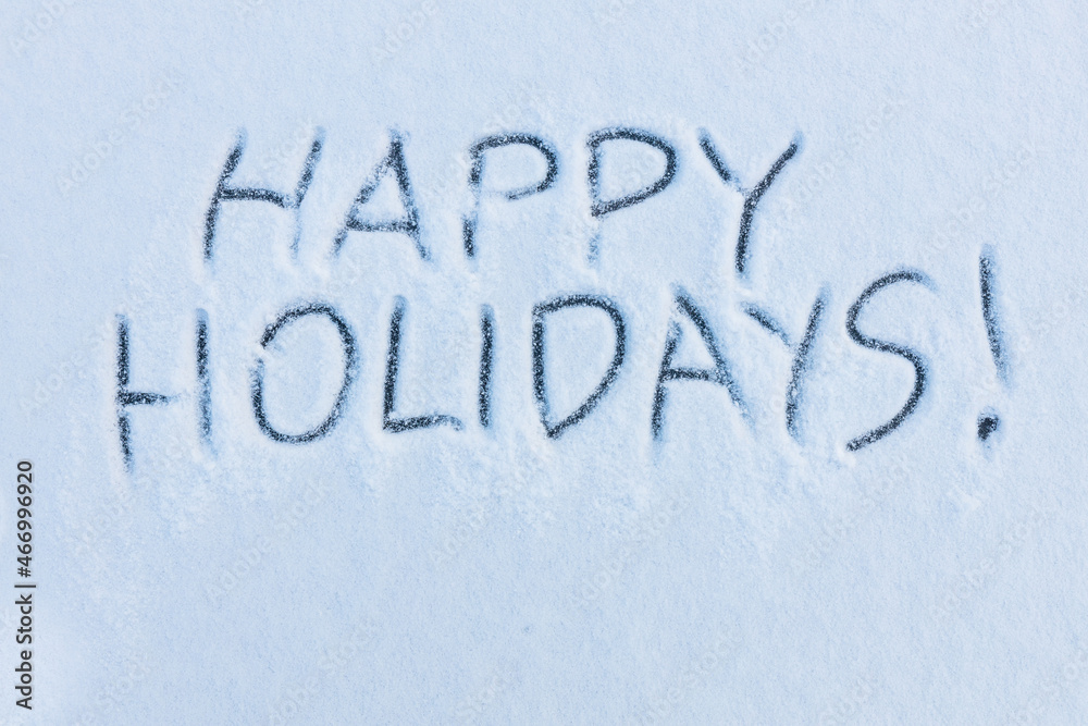 Handwritten message happy holidays on a snowy surface. Winter holidays concept background. Handwritten message happy holidays on a snowy surface. Winter holidays concept background.