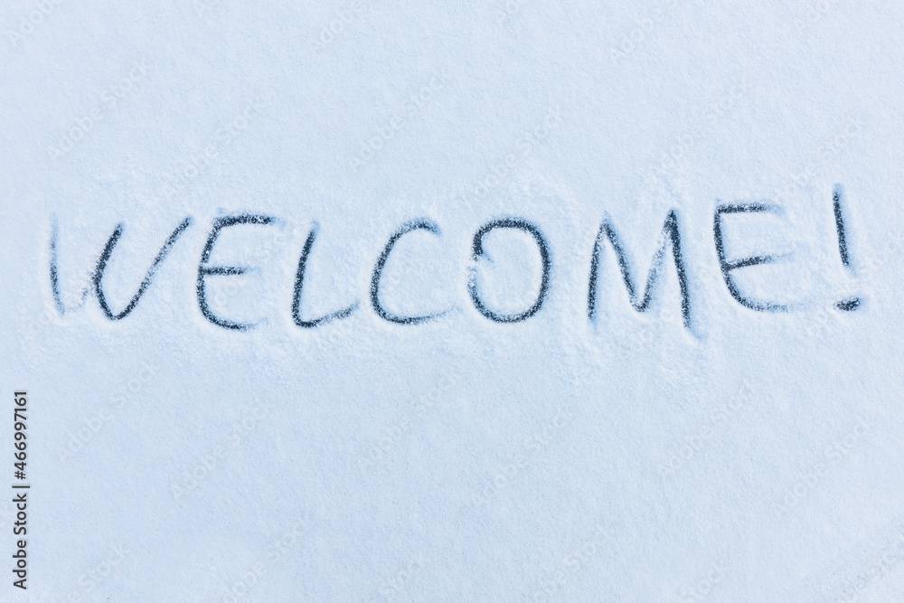 Handwritten word welcome on a snowy surface. Winter holidays concept background. Handwritten word welcome on a snowy surface. Winter holidays concept background.
