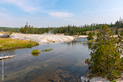 trees, river, Geyser and hot spring in old faithful basin in Yellowstone National Park in Wyoming photo
