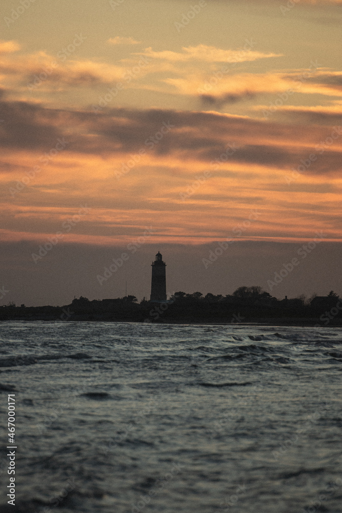 lighthouse at sunset over the ocean