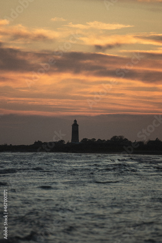 lighthouse at sunset over the ocean