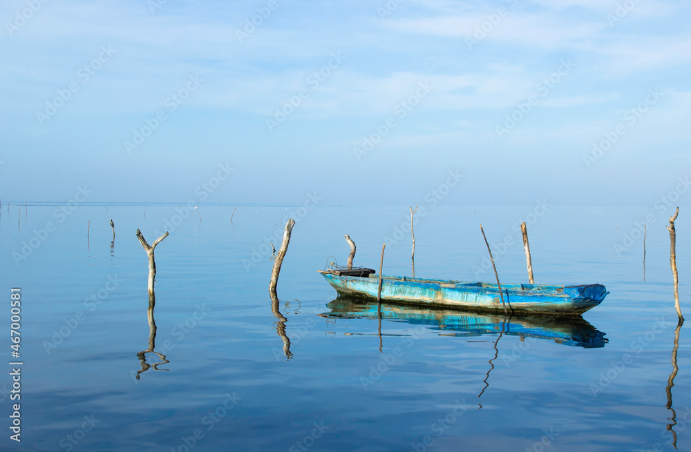 A beautiful view of an isolated boat in the middle of the water with a beautiful blue sky 