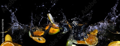 Bright juicy fruits on a dark background with a spectacular splash in ultra wide high definition.