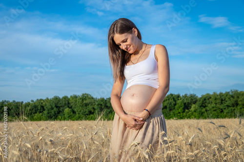 Beautiful pregnant woman walking outdoors with naked belly