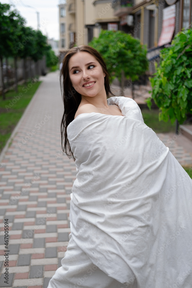 pretty brunette woman in white blanket outdoors. crazy rebel millennial girl