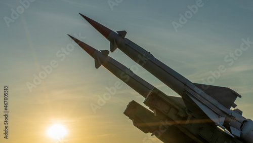 Two combat missiles aimed at the sky. Old ballistic missile launcher on blue sky background. photo