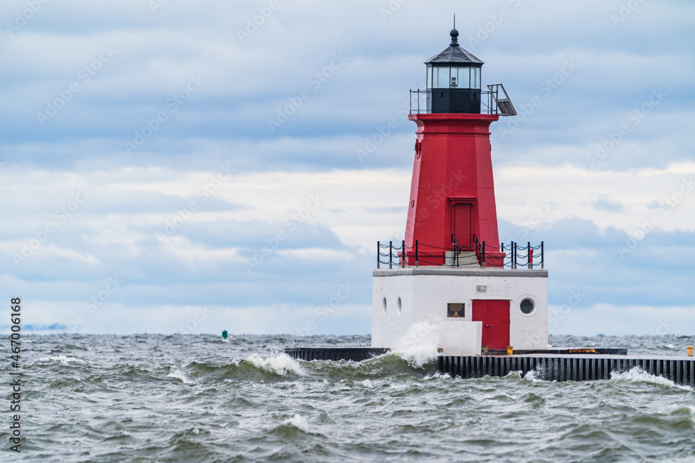 Menominee Pierhead Lighthouse at Ann Arbor Park, as choppy waves of Lake Michigan crash ashore Menominee Pierhead Lighthouse at Ann Arbor Park, as choppy waves of Lake Michigan crash ashore