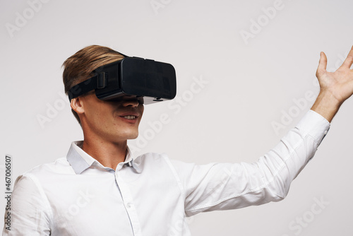 Man in a white shirt vr glasses gadget device video light background