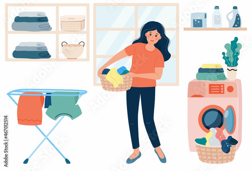 Happy smiling Woman doing laundry at home. Young woman holding basket with clean clothes stand near washing machine.  Housewife doing laundry. Laundry service and housework concept.